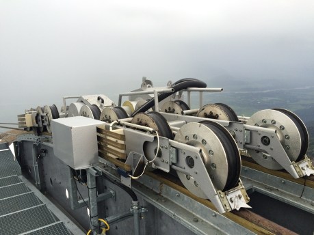 There are 16 wheels on each carriage.  The silver box provides charge to the two batteries in each car when docked.